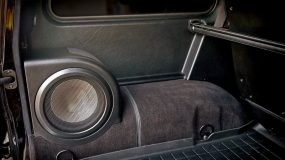 A car audio subwoofer on the left side in the back of a vehicle
