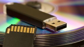 A USB hard drive laying on top of a pile of CDs