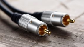 Stereo RCA Plugs on wooden background. Audio cable