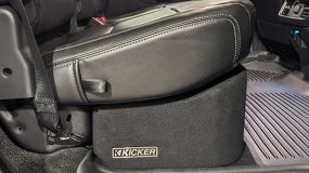 The passenger side seat of a vehicle with the kicker logo on an enclosure underneath it